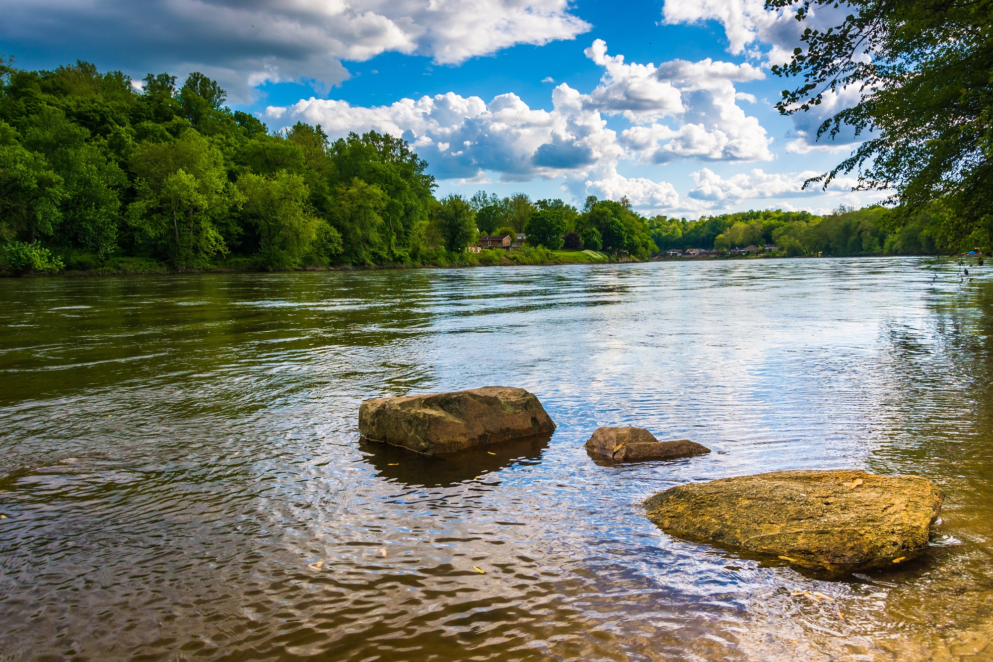 A river flowing through 3 large rocks near the shoreline